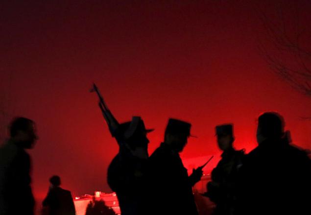 Afghan policemen keep watch near the site of a blast in an area close to the Russian embassy in the west of the capital of Kabul