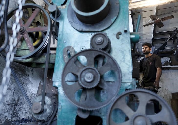 A worker makes parts for scaffolding inside a workshop in an industrial area in Mumbai