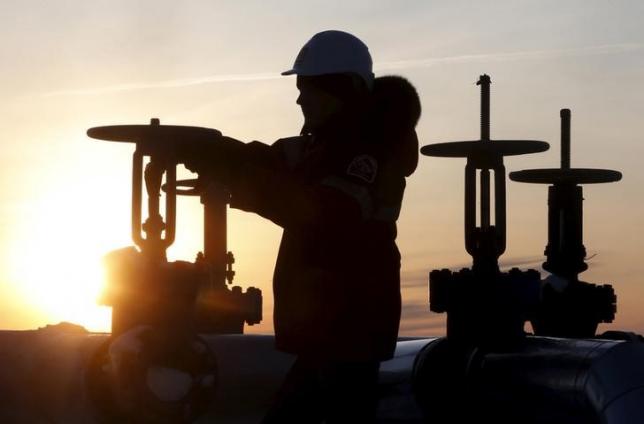 A worker checks the valve of an oil pipe at the Lukoil company owned Imilorskoye oil field outside the West Siberian city of Kogalym Russia