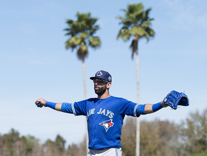 Toronto Blue Jays outfielder Jose Bautista stretches his arms as he walks up the field in the first official workout of spring training in Dunedin Fla. on Monday