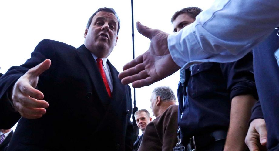 Republican presidential candidate New Jersey Gov. Chris Christie shakes hands with firefighters while visiting a polling station on primary day during a campaign stop in Londonderry N.H. Tuesday Feb. 9 2016