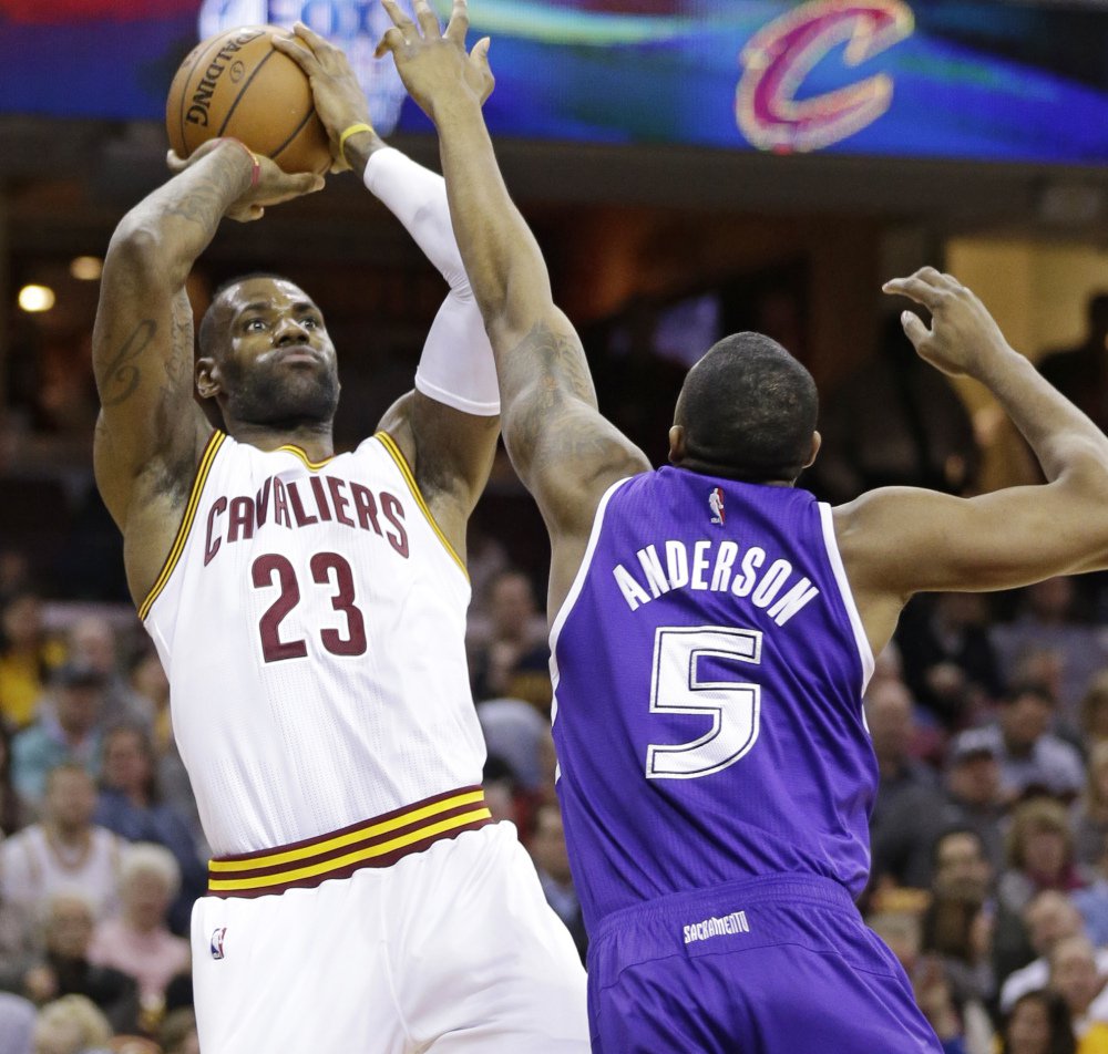 Cleveland’s Le Bron James shoots over Sacramento’s James Anderson in the first half of Cleveland’s 120-110 win Monday in Cleveland. James finished with a triple-double