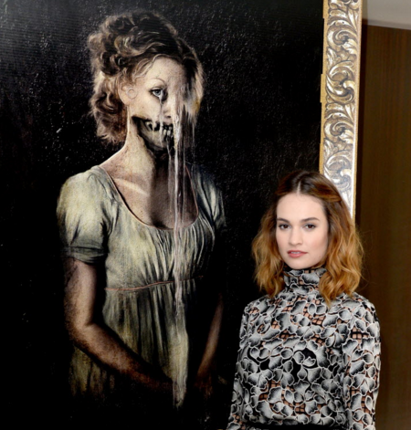 Lily James poses next to a poster depicting one of the'undead from'Pride and Prejudice and Zombies | Kevin Winter  Getty Images