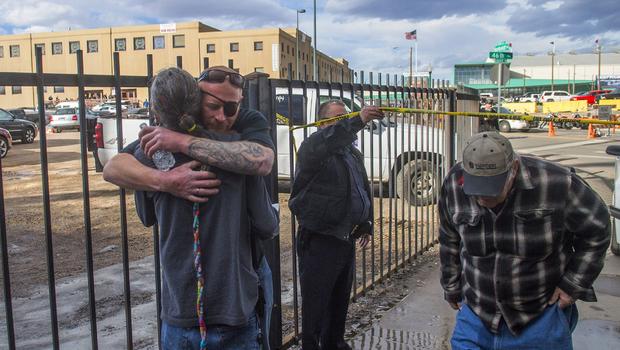 Men hug after a shooting at a motorcycle expo at the National Western Complex in Denver Colorado