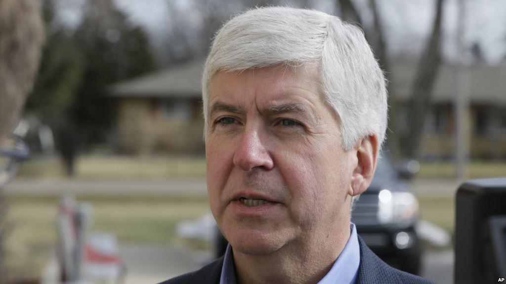 FILE- Michigan Gov. Rick Snyder is interviewed after visited a church that's distributing water and filters to its predominantly Latino parishioners in Flint Michigan Feb. 5 2016