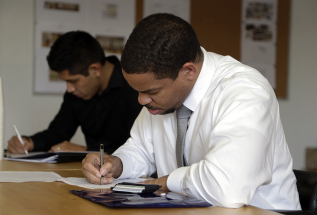 Reece Lightner fills out a job application for a server at a job fair held by The Genuine Hospitality Group in Miam