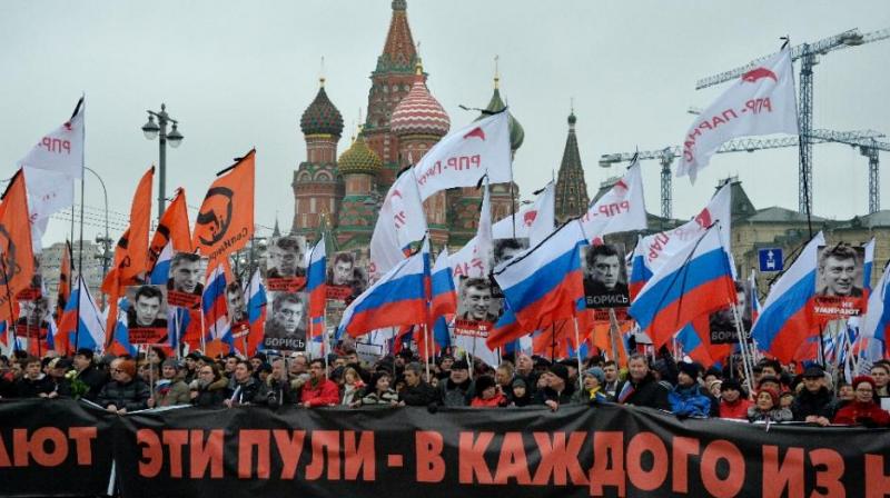 Russia's opposition supporters carry a banner reading “These bullets in each of us” during a march in memory of murdered Kremlin critic Boris Nemtsov in central Moscow