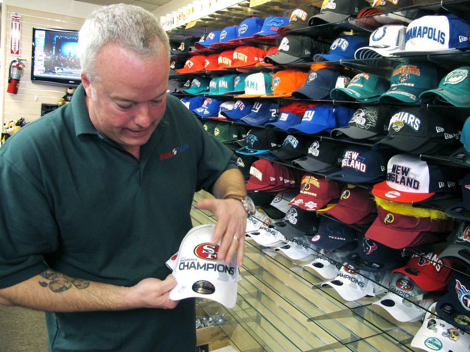 Fans will spend plenty on NFL merchandise like the hats sold by Andy Hageman of the House of Football in Albuquerque