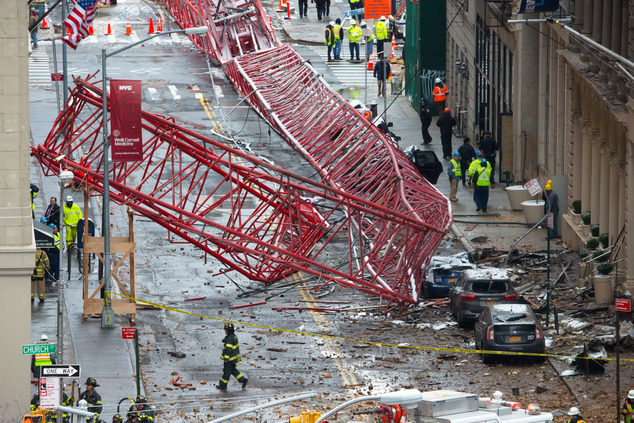 A collapsed crane fills the street on Friday Feb. 5 2016 in New York. The huge construction crane was being lowered to safety in a snow squall when plumme