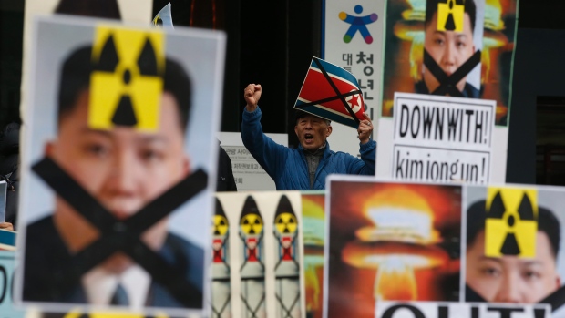 A South Korean man holding a crossed North Korean flag shouts slogans among placards with crossed portraits of North Korean leader Kim Jong-un pasted with the radiation warning symbol during an anti North Korea rally in downtown Seoul on Thursday