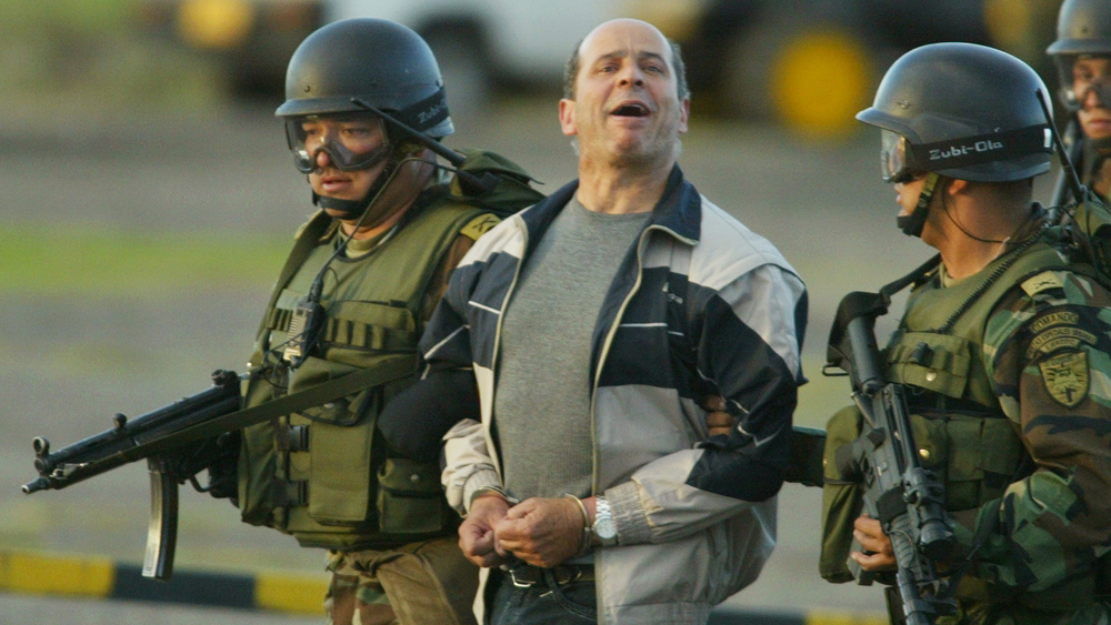 Ricardo Palmera known as Simon Trinidad a leader of the Revolutionary Armed Forces of Colombia FARC shouts slogans as he is escorted by soldiers at a military base in Bogota in this Jan. 3 2004 file