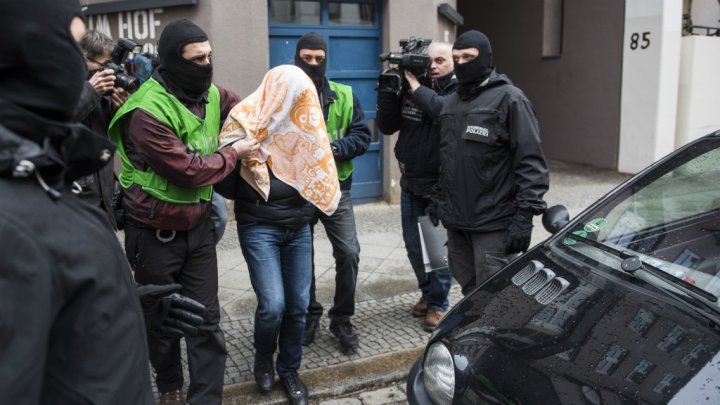 Odd Andersen AFP | German police escort a man who was arrested during a raid