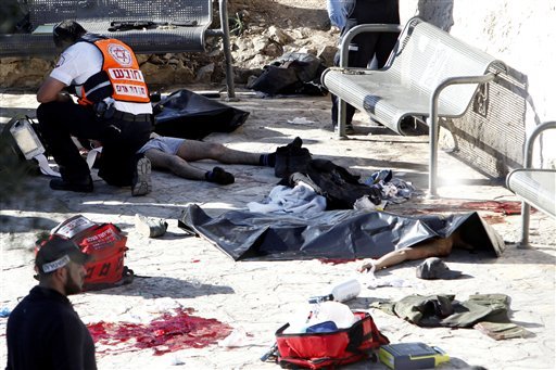 An Israeli medic inspects the body of a Palestinian at the scene of a shooting attack near the Damascus gate Jerusalem's Old City Wednesday Feb. 3 2016. Three Palestinians carrying automatic weapons explosive devices and knives shot and stabbed two I