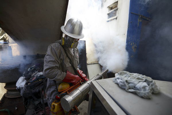 A Health Ministry employee fumigates against Aedes Aegypti mosquito at a home in Caracas. Venezuela has recorded 4,700 suspected cases of people infected by the Zika virus which is thought to cause brain damage in babies the health ministry said. — A