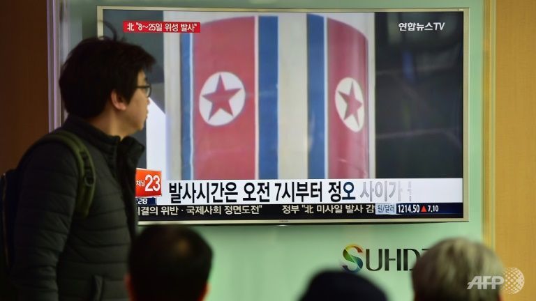 People watch a news report on North Korea's planned rocket launch at a railway station in Seoul