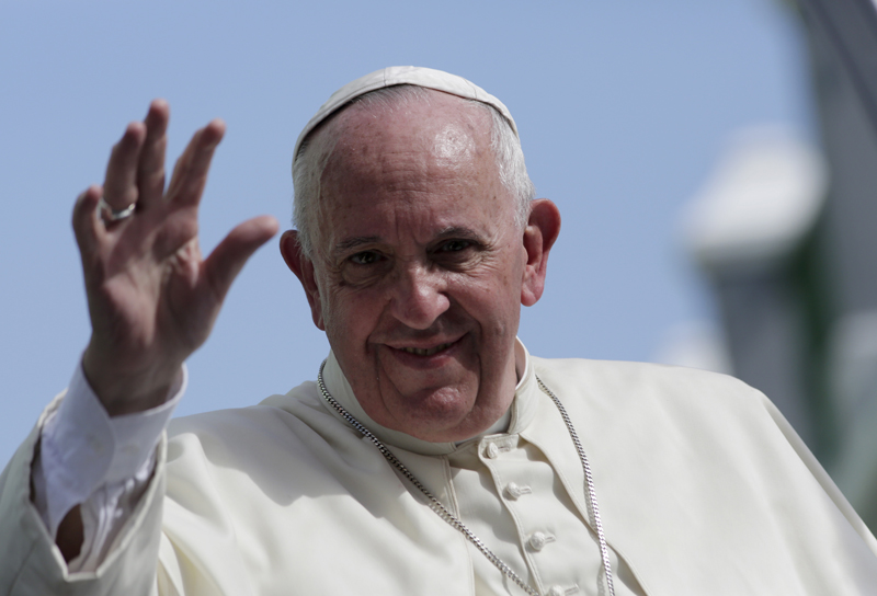 Pope Francis waves while riding through Santiago de Cuba