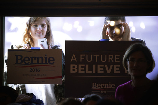 Members of the pubic peek through the window as Democratic presidential candidate Sen. Bernie Sanders speaks to voters during a campaign event at Cafe Dodici