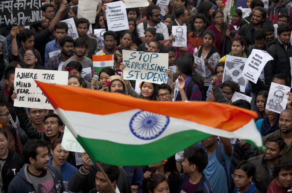 Indian students wave an Indian flag and shout slogans during a protest at the Jawaharlal Nehru University against the arrest of a student union leader in New Delhi India Thursday Feb. 18 2016