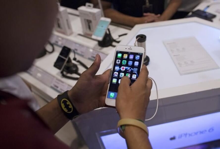 REUTERS  Danish Siddiqui  FilesA man inspects the Apple iPhone 6 Plus at an electronics store in Mumbai India