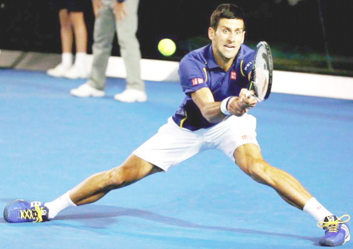 Serbia’s Novak Djokovic plays a backhand shot during yesterday’s Australian Open men’s singles final against Britain’s Andy Murray in Melbourne Australia.. Inset Djokovic kisses the Australian Open trophy. Phot