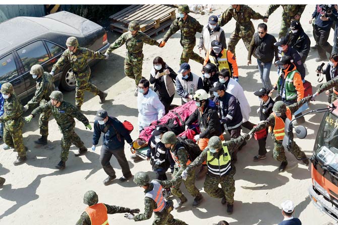 Rescuers carry Li Tsung-tian out of the site of the quake. PIC  AFP