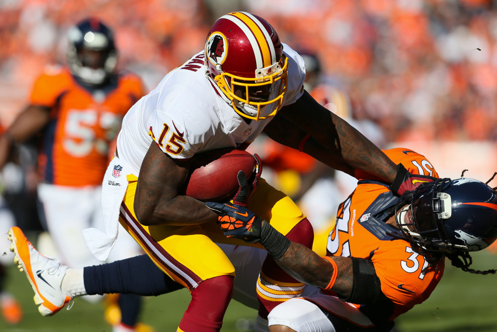 27 October 2013 Washington Redskins wide receiver Josh Morgan stiff arms Denver Broncos cornerback Omar Bolden on a return during a game between the Denver Broncos and the Washington Redskins at Sports Authority Field at Mile High Denver CO