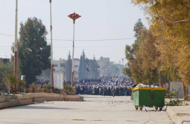 A crowd waits on the edge of a buffer zone that was created in preparation for a food aid distribution in the besieged town of Moadamiyeh Syria which was a joint operation between the Syrian Arab Red Crescent and the International Committee of