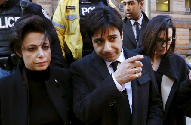 Jian Ghomeshi a former celebrity radio host who has been charged with multiple counts of sexual assault leaves the courthouse after the first day of his trial alongside his lawyer Marie Henein, in Toronto on Monday