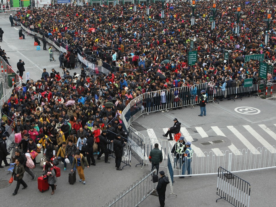 Policemen control the stranded passengers entering Guangzhou Railway Station after trains were delayed as they prepare going back to their hometown ahead of the Chinese Lunar New Year