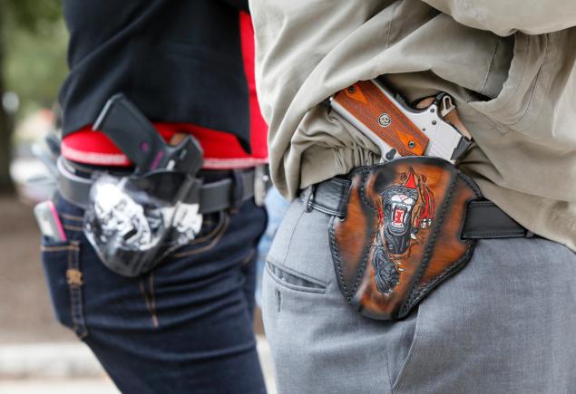 Art and Diana Ramirez carry their pistols in custom-made holsters during an open-carry rally at the Texas State Capitol in Austin on Jan. 1. A law that goes into effect Aug. 1 says that higher education institutions Texas cannot ban concealed handguns fro