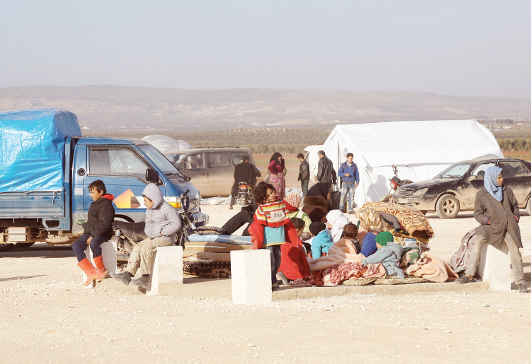 Syrians fleeing the conflicts in Azaz region wait at the Bab Al Salam border gate in Syria Friday. — AP