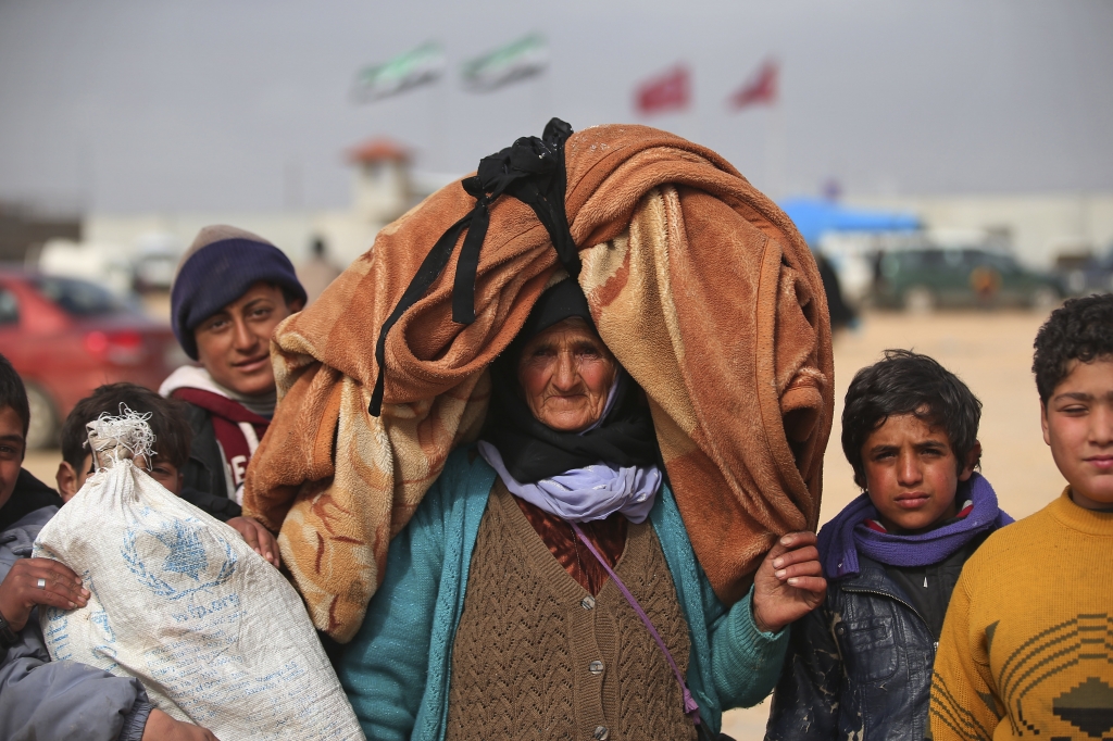 Syrians head toward the Bab al Salam border crossing with Turkey on Saturday in Syria