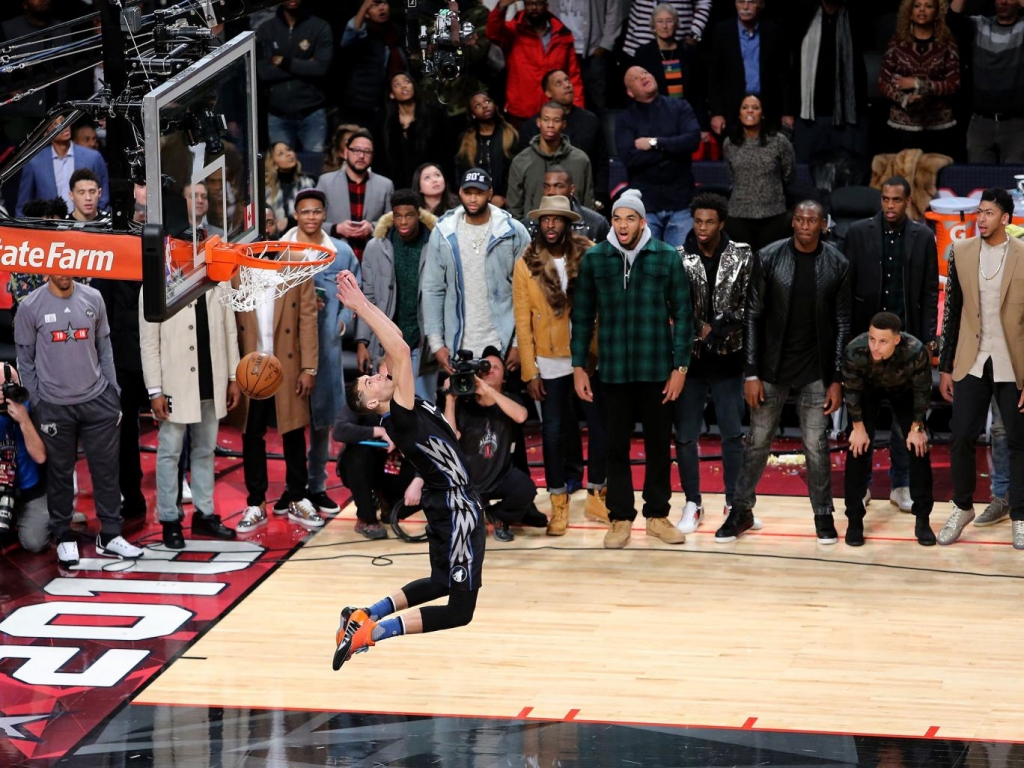 Zach La Vine of the Minnesota Timberwolves dunks as NBA players look on in the Verizon Slam Dunk Contest during NBA All Star Weekend