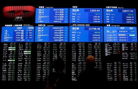 Visitors looks at an electronic board showing the Japan's Nikkei average at the Tokyo Stock Exchange in Tokyo Japan