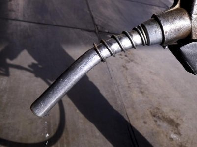 A worker grabs a nozzle at a petrol station in Tehran Iran