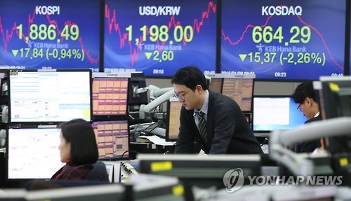 Traders monitor share prices at a local bank