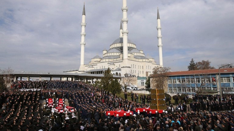 Honour guards carry the Turkish flag-draped coffins of car bombing victims during a funeral ceremony at Kocatepe Mosque in Ankara