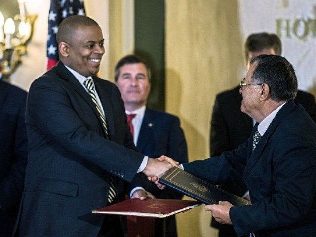 Transportation Secretary Anthony Foxx and Cuban Minister of Transportation Adel Yzquierdo shake hands after signing an agreement authorizing up to 110 scheduled daily commercial flights to Havana and nine other destinations on the island at National H