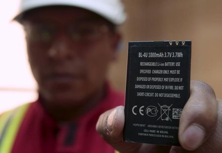 A worker holds a rechargeable lithium battery that is made in Bolivia at a plant in Llipi at the border of Uyuni salt lake