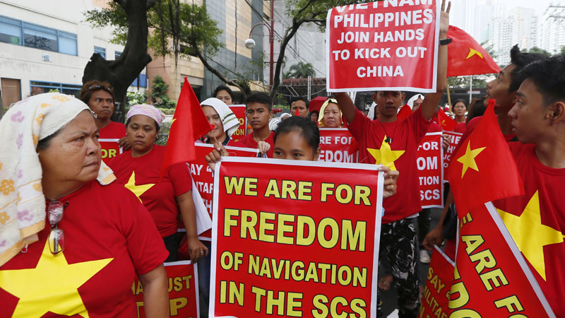 Filipinos together with Vietnamese expatriates display placards during a rally at the Chinese Consulate to protest China's island-building and deployment of surface-to-air missile system at the disputed Paracel Islands off South China Sea Thursday Feb