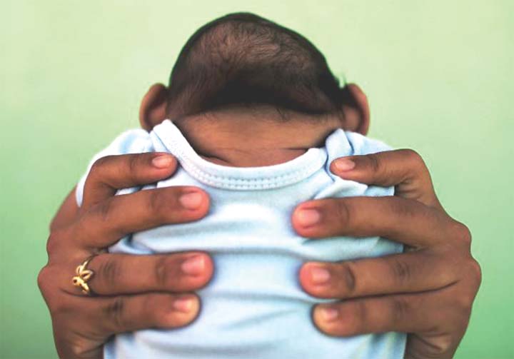 Jackeline 26 holds her son who is 4 months old and born with microcephaly in front of their house in Olinda near Recife Brazil