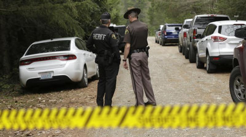 Mason County Sheriff's Chief Criminal Deputies Russ Osterhout left and Ryan Spurling right stand on a road near the scene of a fatal shooting near Belfair Washington