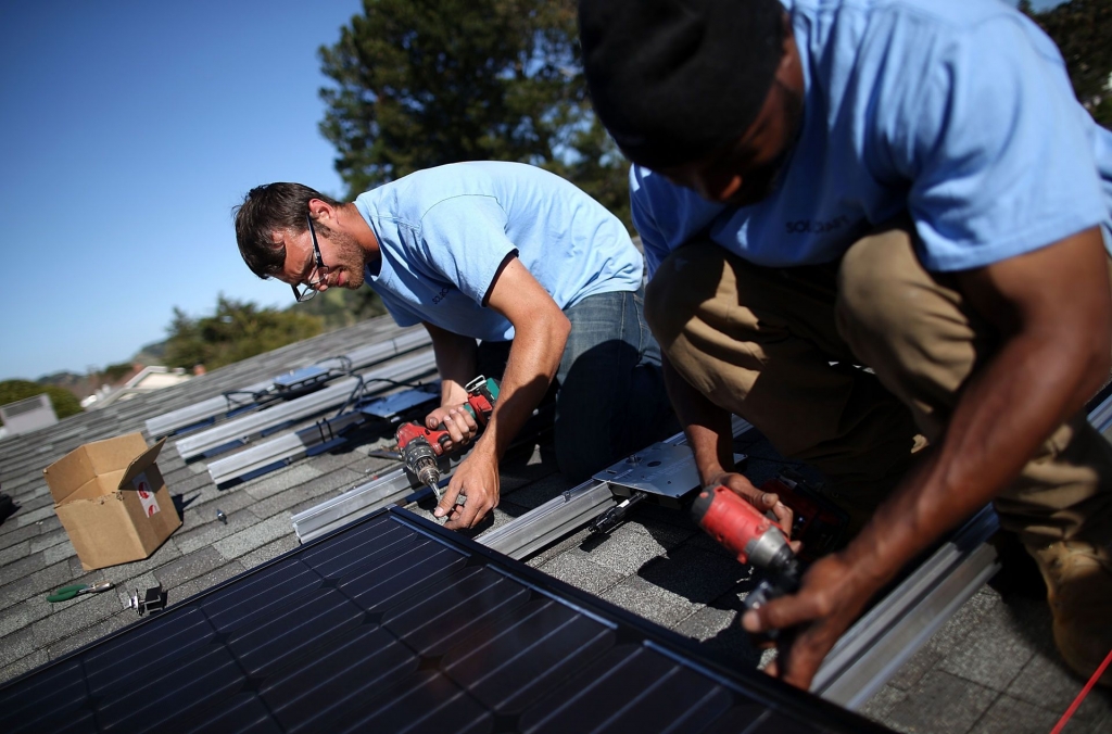 Workers install solar panels on a home in San Rafael February 2015