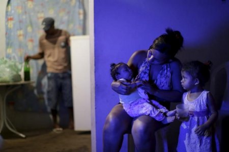 Rosana Vieira Alves holds her 4-month-old daughter Luana Vieira who was born with microcephaly as her daughter Laiane Sophia looks on at their home in Olinda Brazil