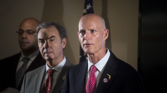 Scott right holds a press conference on Thursday Feb. 4 2016 at the at the Hillsborough County Health Department after his decision to declare a state of emergency in five counties affected by the Zika virus. Scott explains