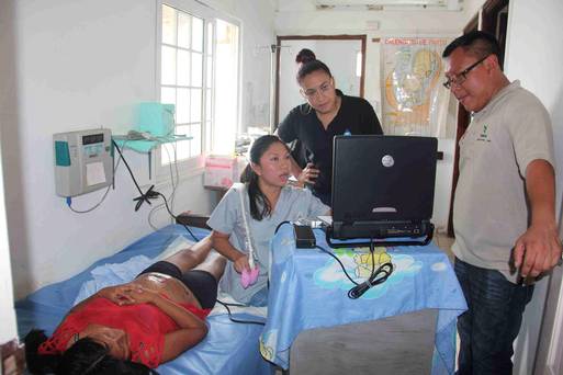 A Guna indigenous woman lies down during an ultrasound scan given by a health worker in Carti in the region of Guna Yala in this handout taken