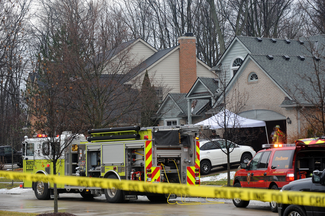 Police and fire officials investigate a house fire that killed five people at a home in Novi Mich. Sunday Jan. 31 2016. Authorities say five restaurant