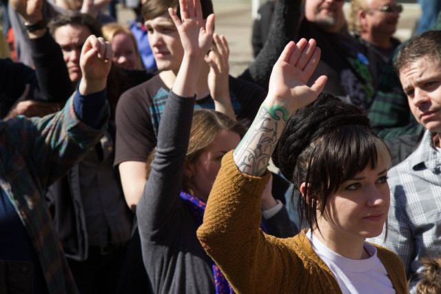 Caucus-goers raise their hands during Washington state's Democratic caucus