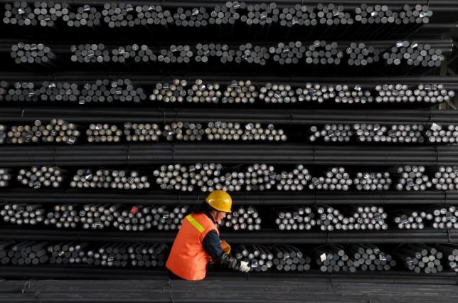 A labourer marks steel bars at a steel and iron factory in Huai'an Jiangsu province China in this