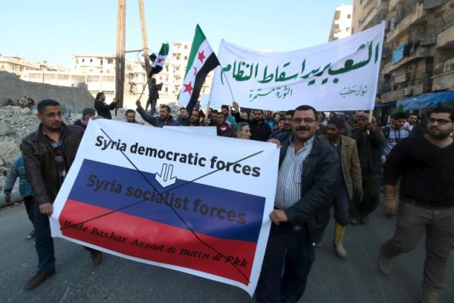 People attend a protest against forces loyal to Syria's President Bashar al-Assad Russia and the Syrian Democratic forces in Tariq al Bab neighbourhood of Aleppo Syria